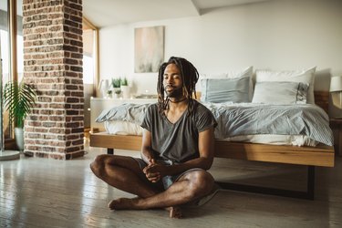 A man learning how to meditate in his bedroom at home